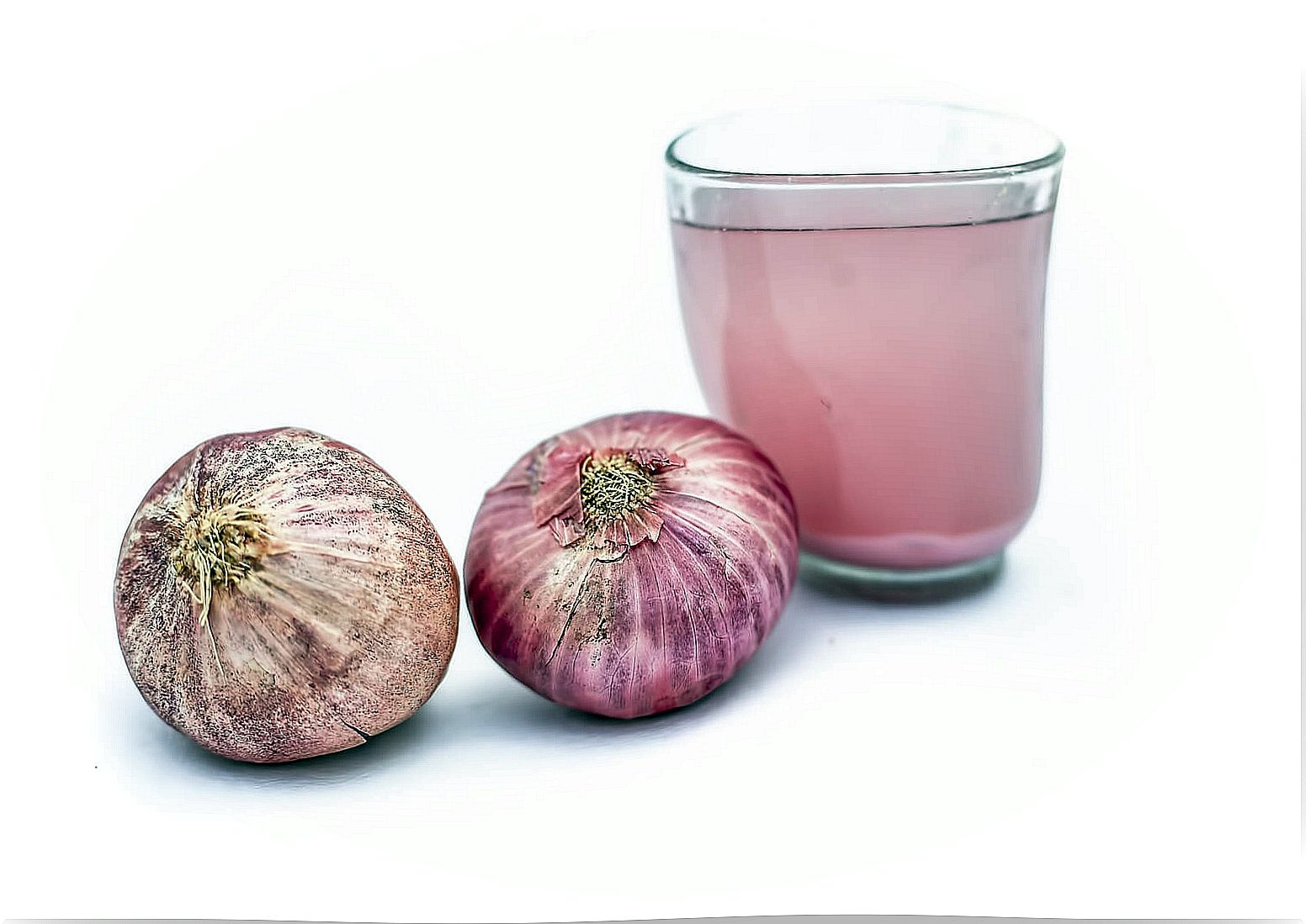 Glass with onion juice and purple garlic.