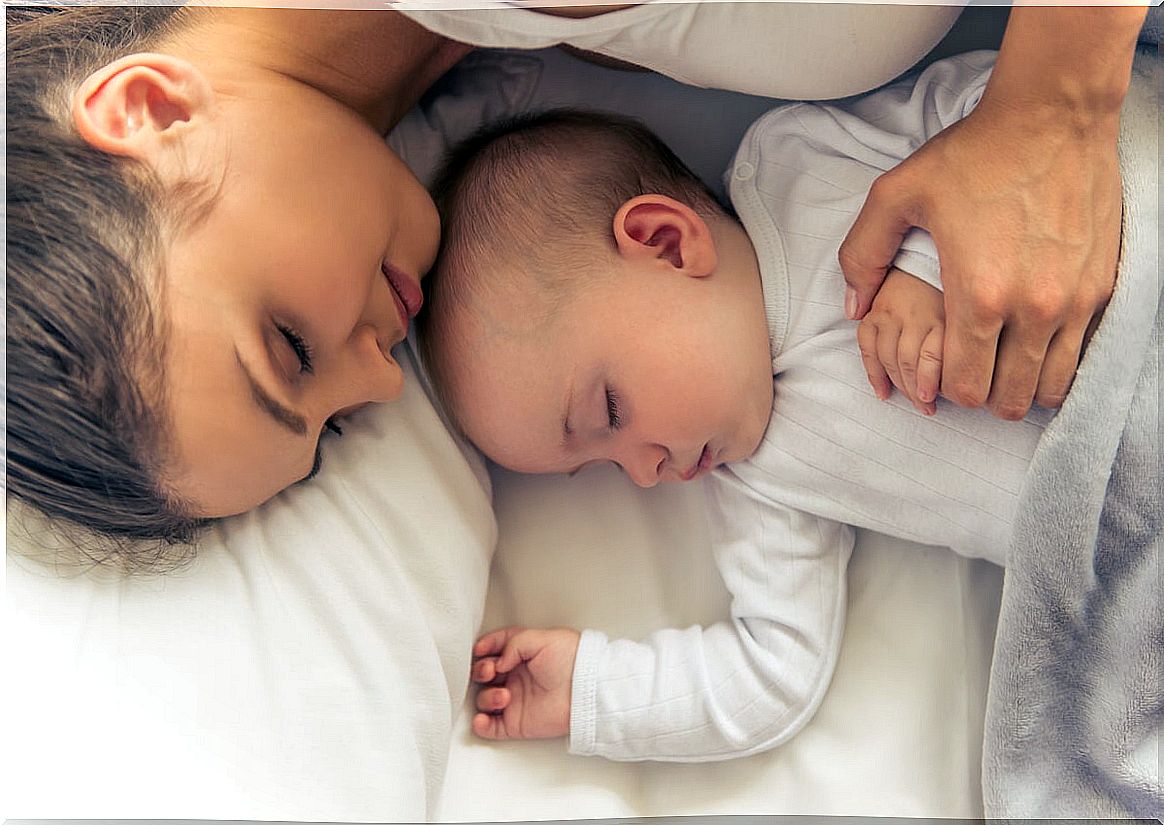 Mother practices co-sleeping with baby.