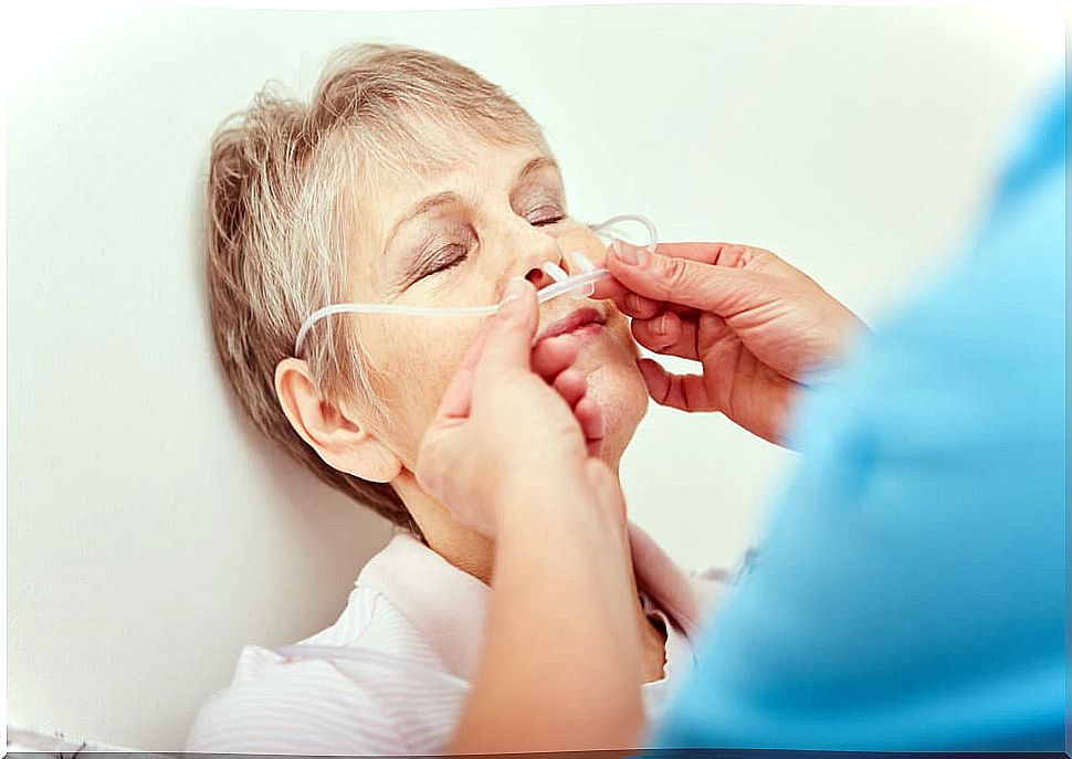 Male nurse applying a nasogastric tube to an elderly woman.