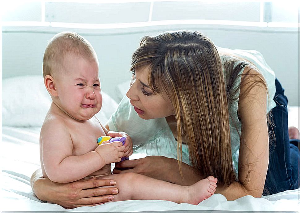 A mother tending to her crying baby.